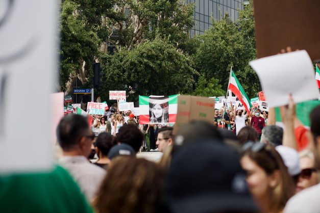 Folk på gaden med iranske flag - det er en demonstration mod styret i Iran